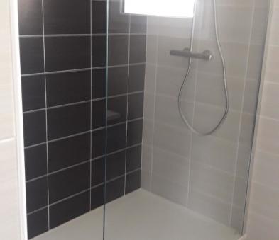 Espace douche avec receveur hydrobox en gelcoat coloris blanc, paroi fixe de chez Novellini, robinetteries de chez GRB, faïence talis antracita et blanco de chez PORCELANOSA