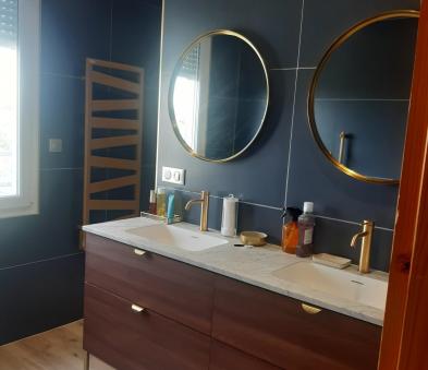 Meuble doubles vasques coloris noyer, miroir rond cadre doré de chez Randalpro