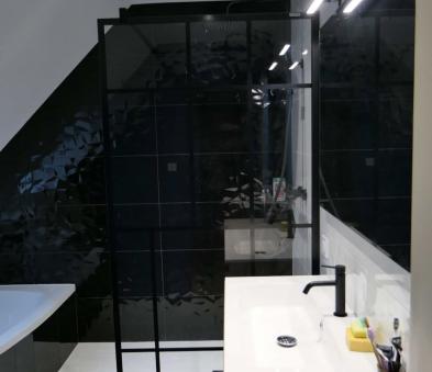 Faïence noir brillant relief, receveur hydrobox, paroi type verrière de chez PROFILTEK, baignoire asymétrique Marina